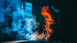 person welding wearing a prootective metal mask