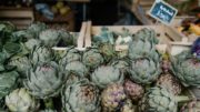 ripe artichokes in boxes in market